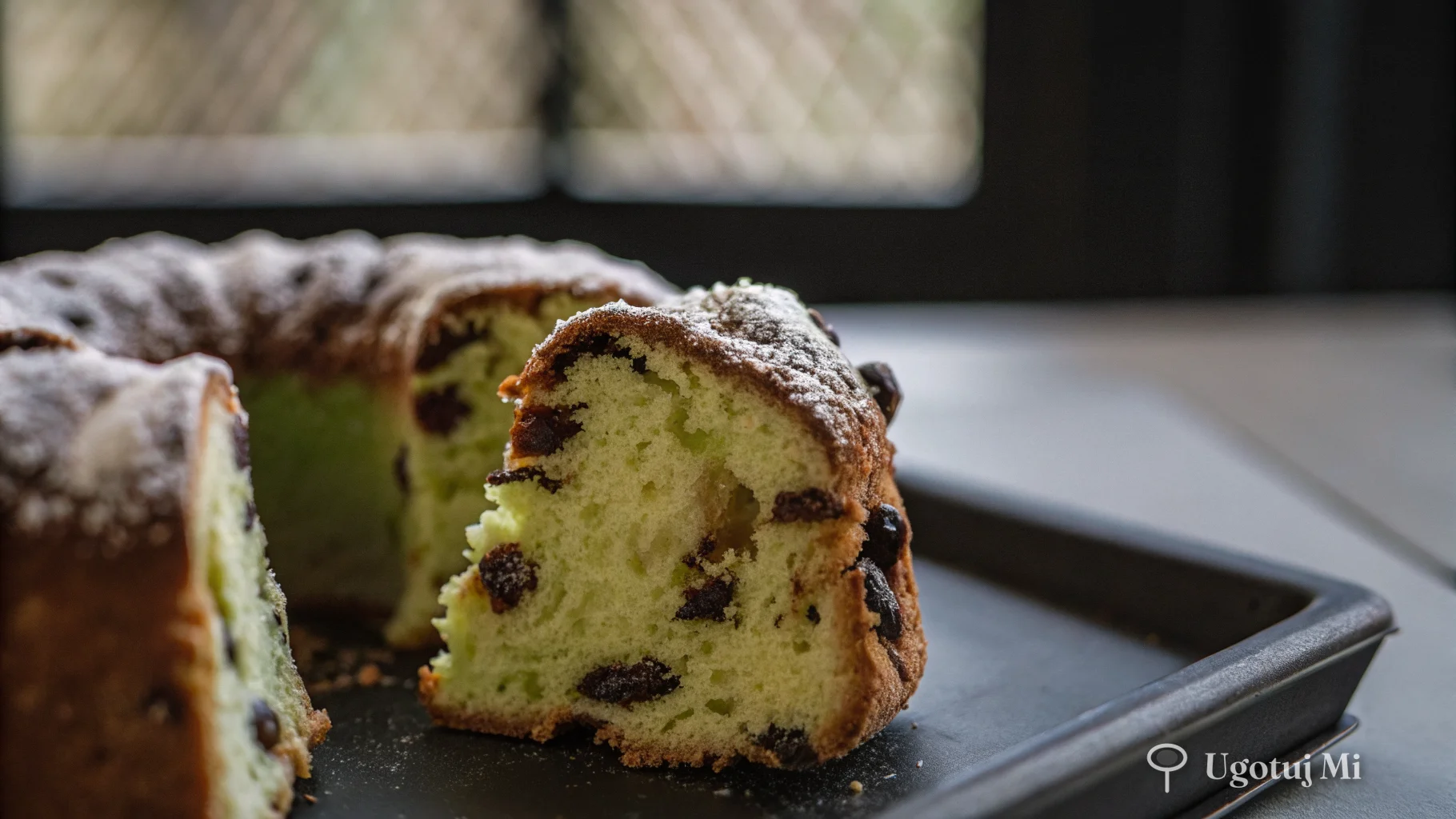 Przekrój babki drożdżowej pokazujący puszystą teksturę z rodzynkami | ugotujmi.pl