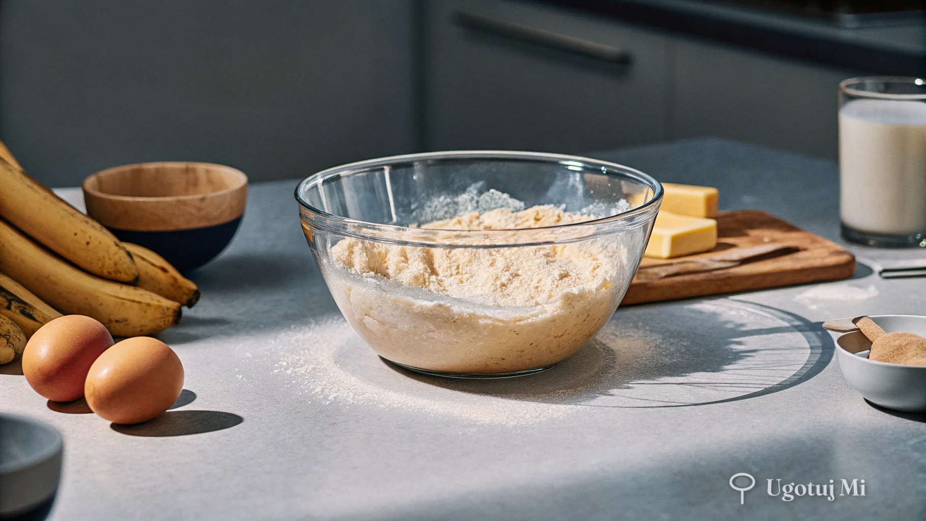 Ciasto do chlebka bananowego w misce z rozgniecionymi bananami i składnikami dookoła | ugotujmi.pl