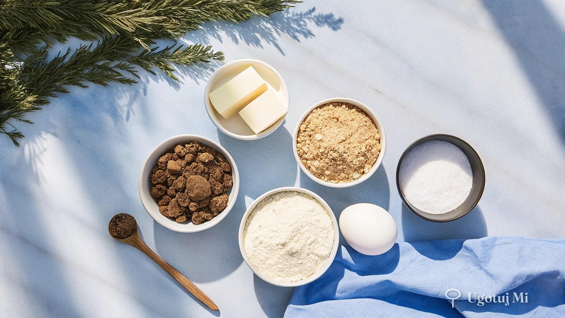 Składniki na ciasteczka owsiane rozłożone na marmurowym blacie – płatki owsiane, czekolada, masło i mąka | ugotujmi.pl