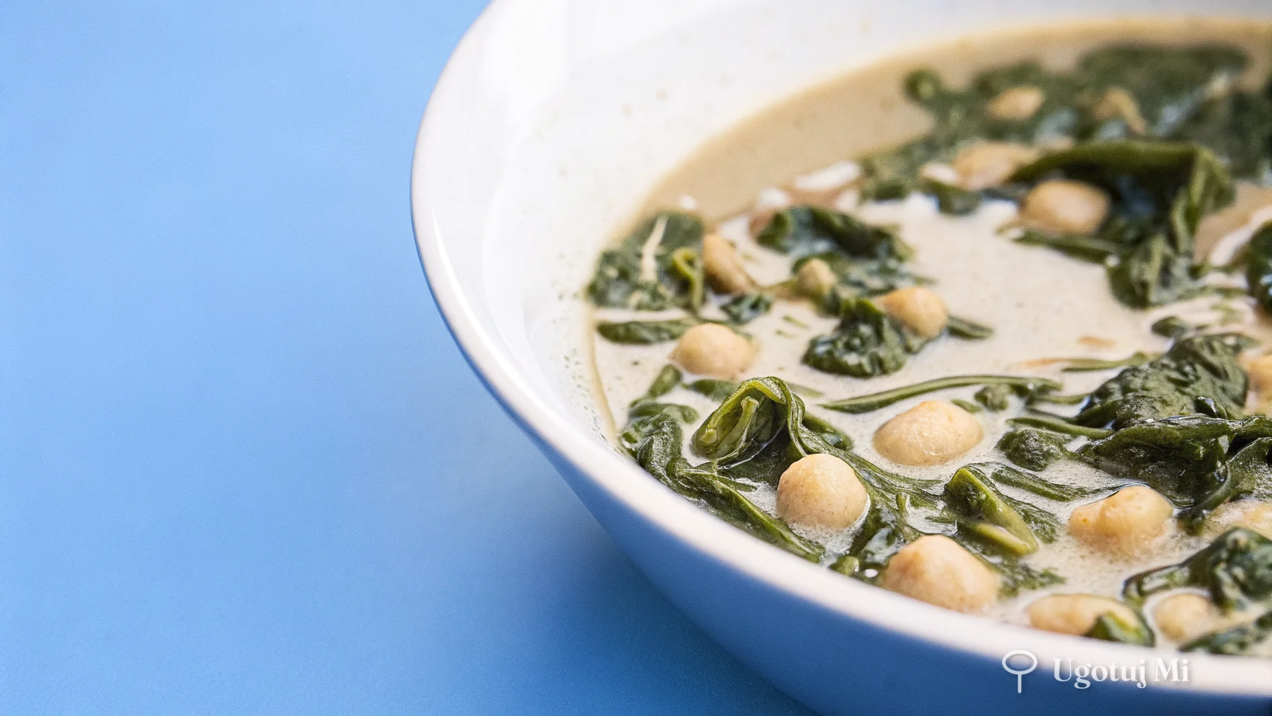 Zbliżenie na ciecierzycę i szpinak w gęstym sosie curry z mleczkiem kokosowym | ugotujmi.pl