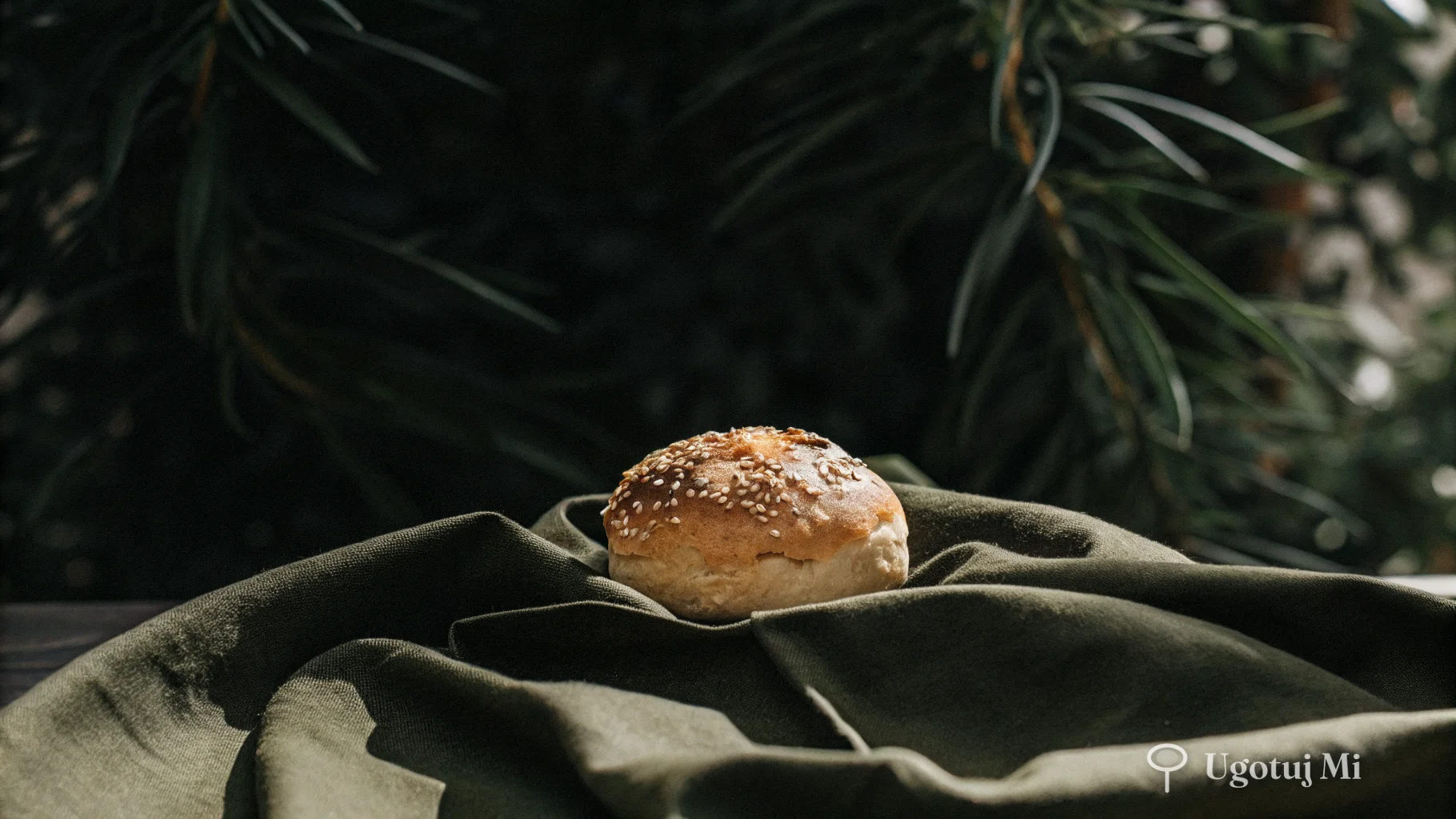 Zbliżenie na bułkę drożdżową posypaną sezamem z chrupiącą skórką | ugotujmi.pl