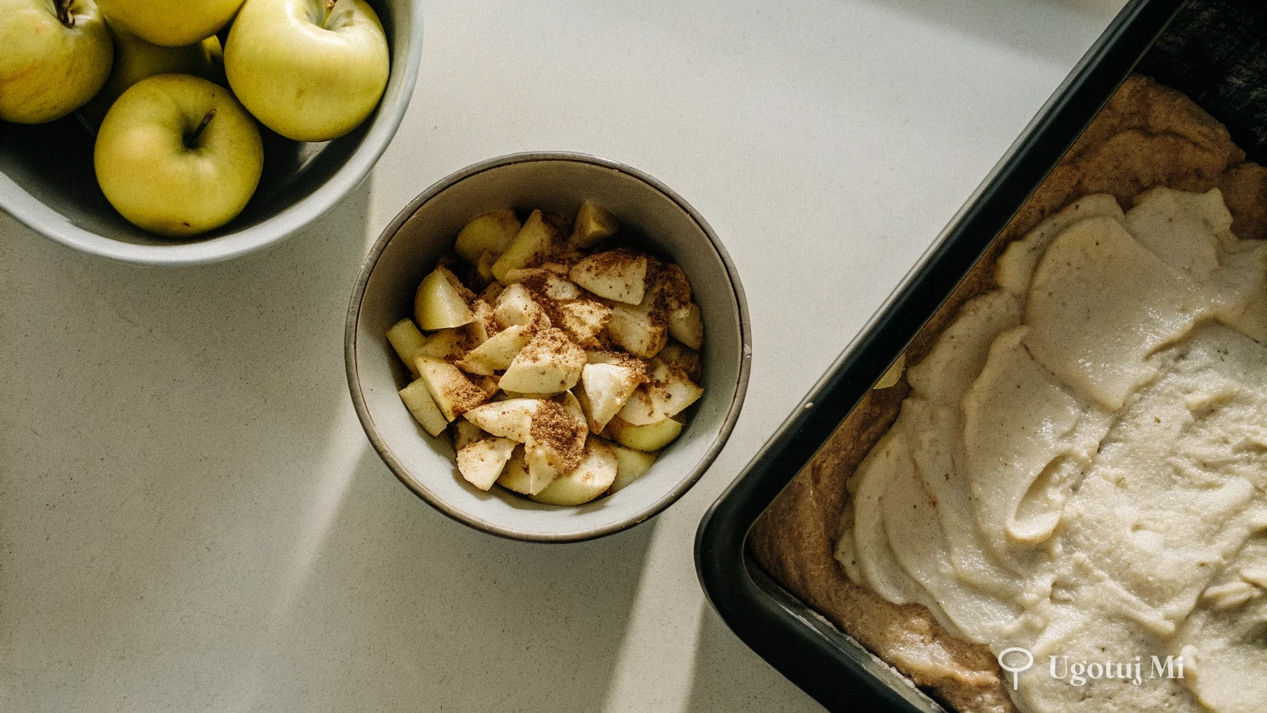 Nadzienie jabłkowe z cynamonem w misce obok blaszki z ciastem przed pieczeniem | ugotujmi.pl