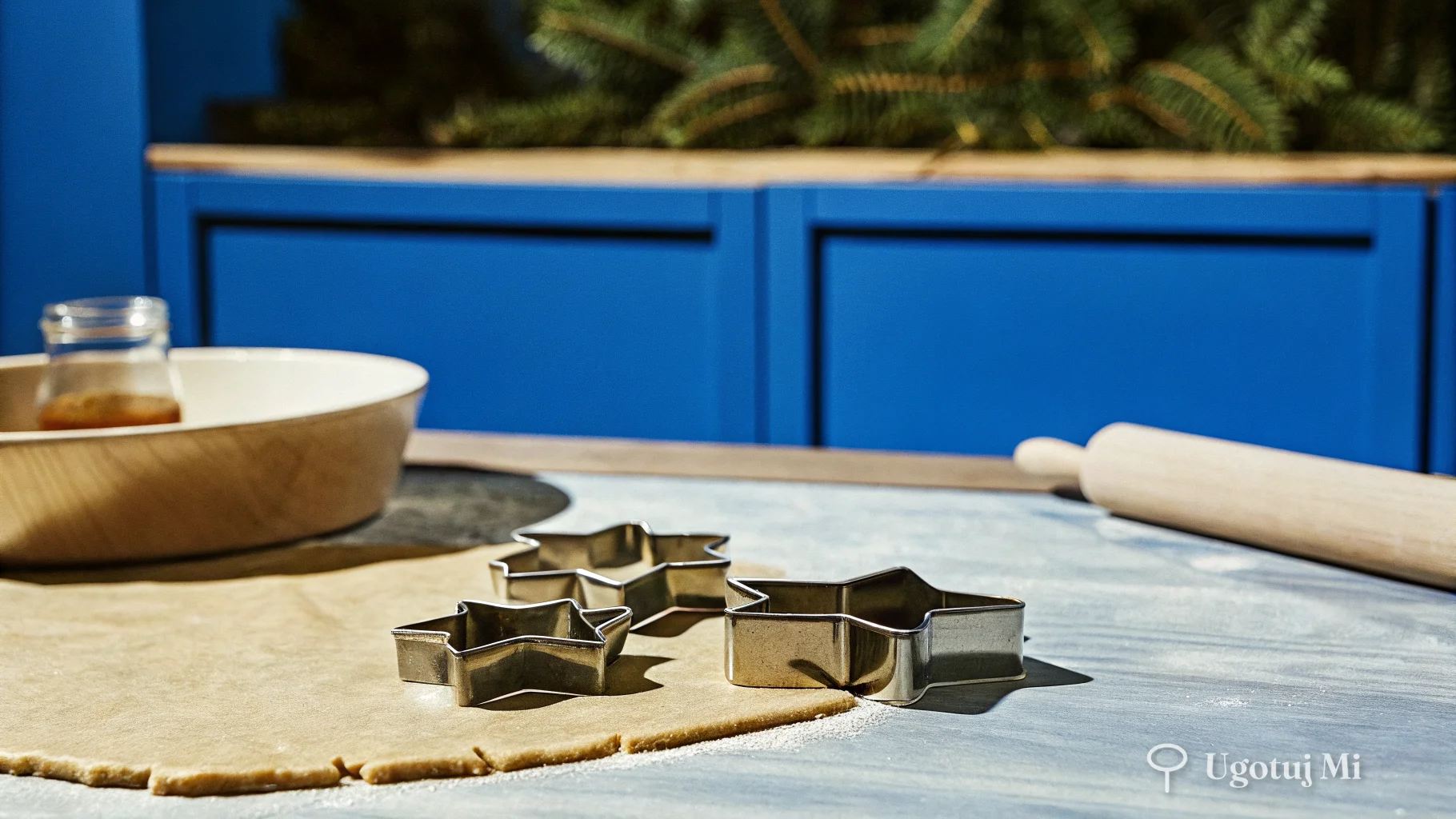 Ciasto piernikowe rozwałkowane na stolnicy z foremkami do wycinania ciasteczek | ugotujmi.pl