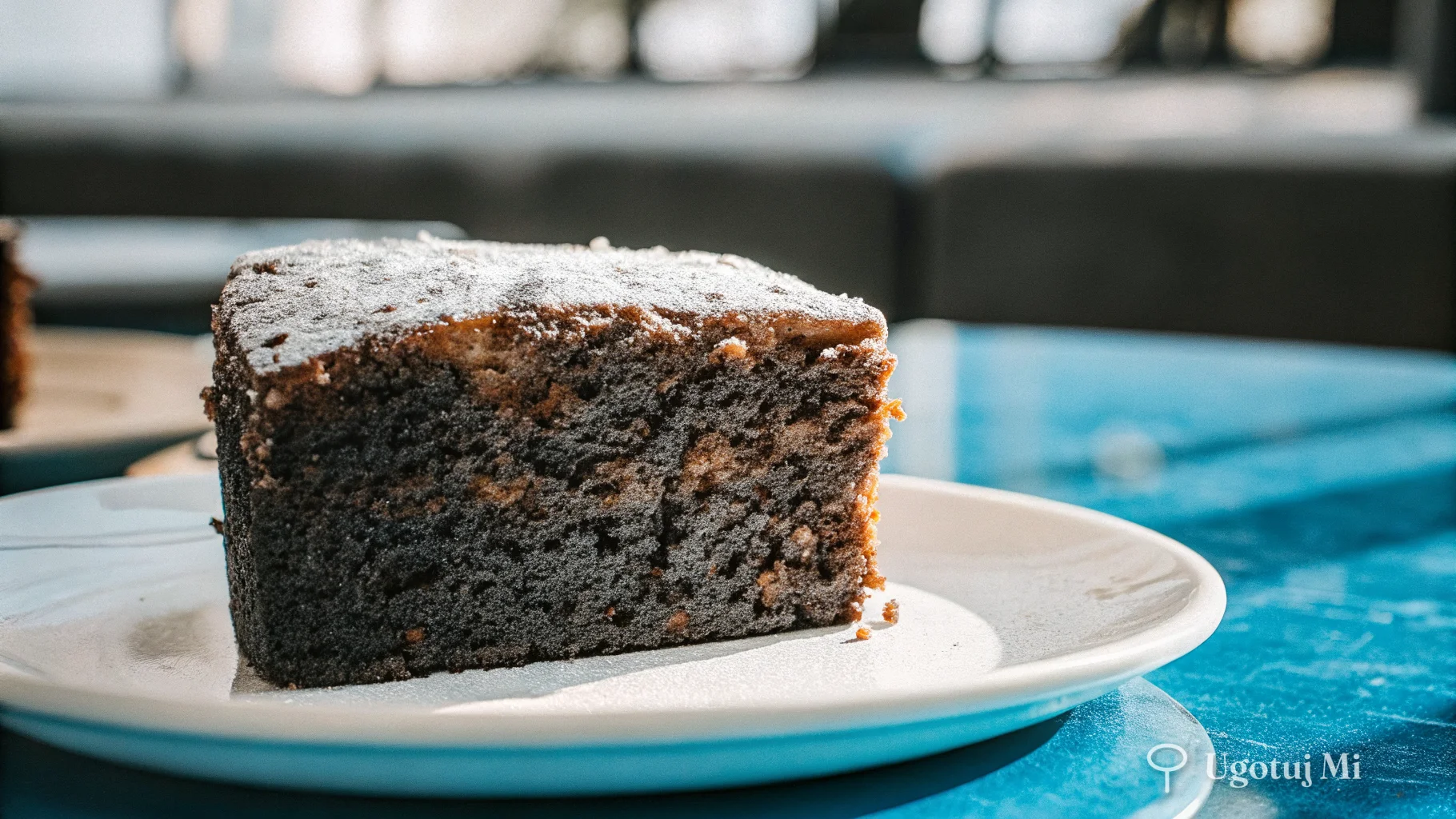 Przekrojony kawałek murzynka pokazujący wilgotny, ciemny miąższ ciasta | ugotujmi.pl