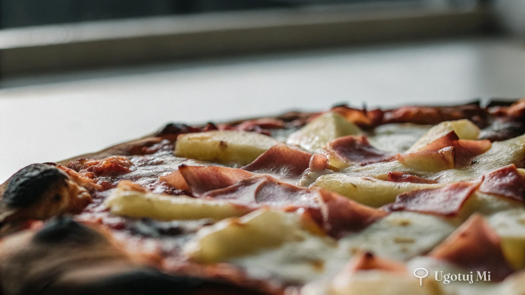 Szczegół pizzy hawajskiej z roztopioną mozzarellą i karmelizowanym ananasem | ugotujmi.pl