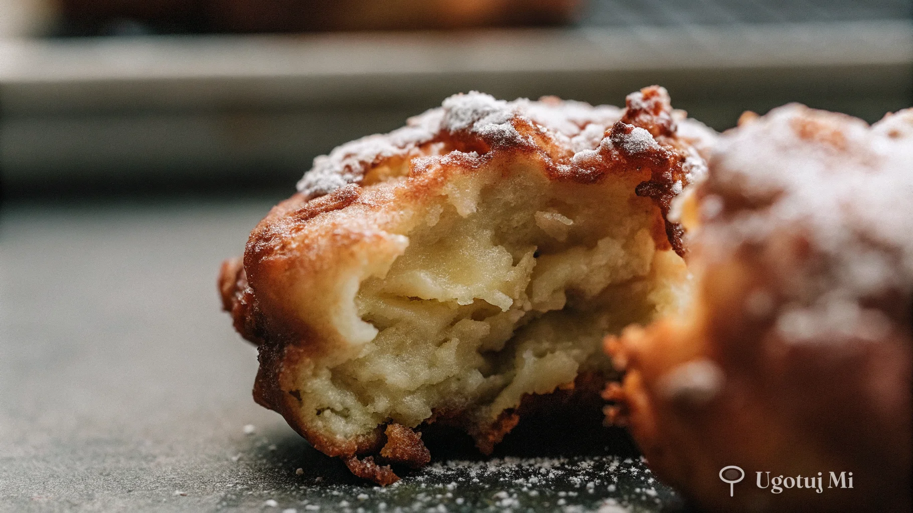Zbliżenie na puszysty racuch z jabłkami z widoczną teksturą i cukrem pudrem | ugotujmi.pl