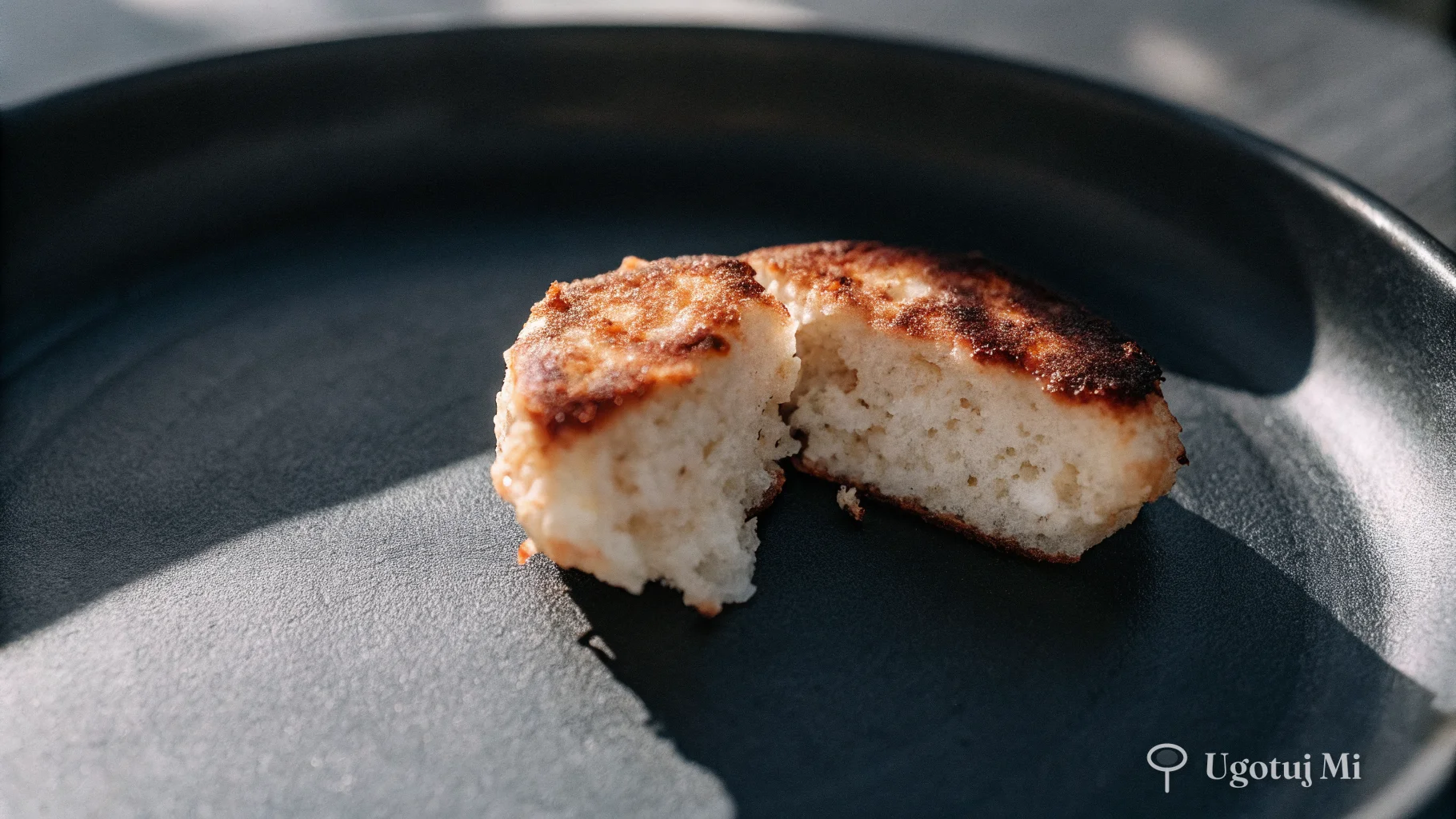 Zbliżenie na przekrojony racuchu z twarogiem pokazujące puszysty, miękki środek i złocistą skórkę | ugotujmi.pl