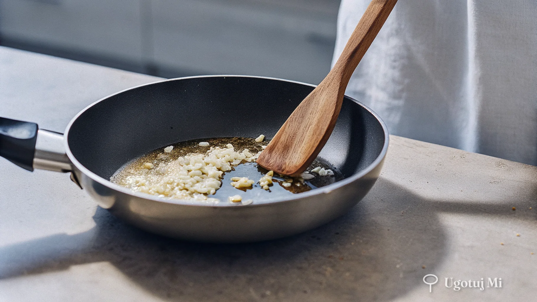 Smażenie czosnku z masłem na patelni podczas przygotowania sosu | ugotujmi.pl