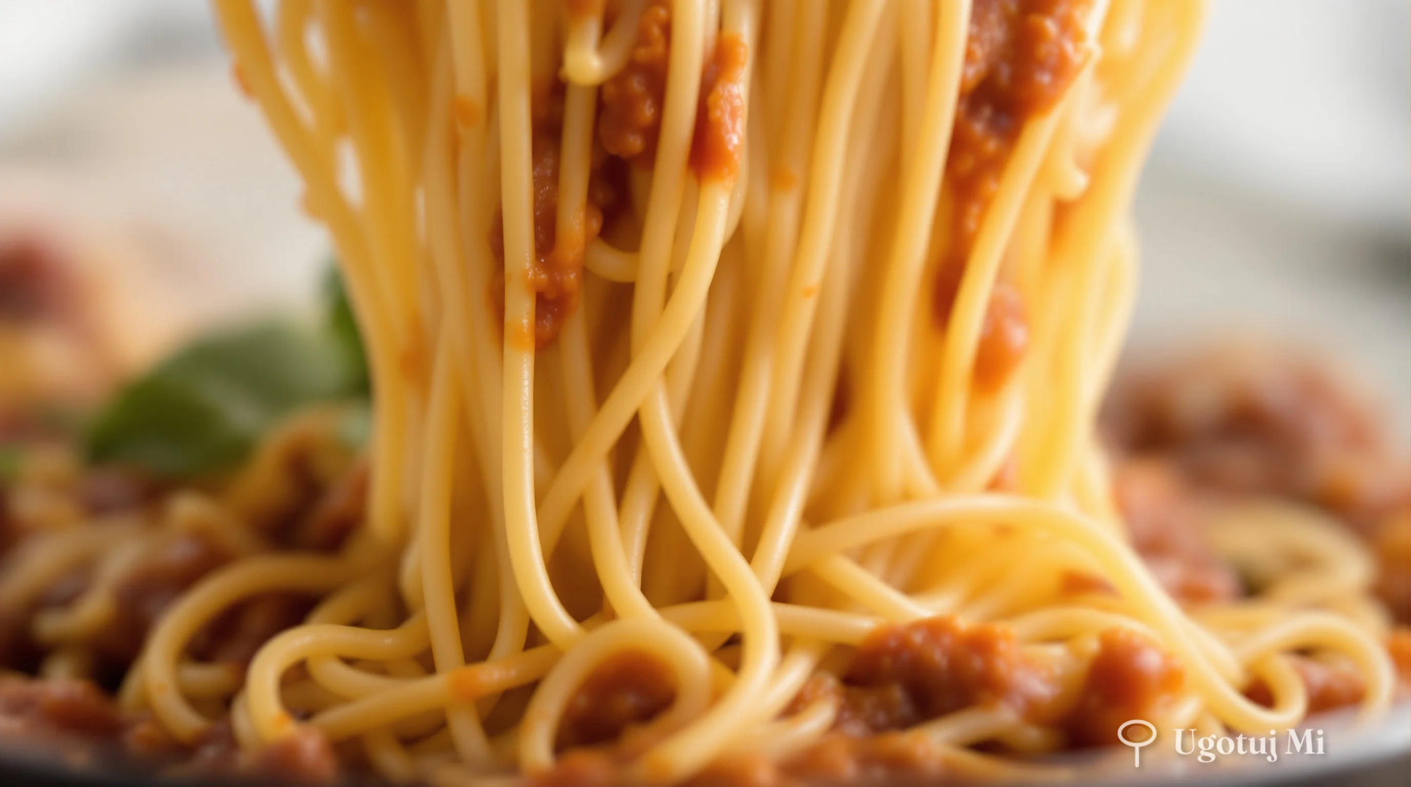 Zbliżenie na spaghetti mieszane z gęstym sosem mięsnym | ugotujmi.pl