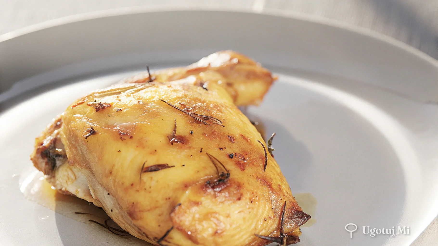 Zbliżenie na chrupiącą złocistą skórkę kurczaka z ziołami | ugotujmi.pl