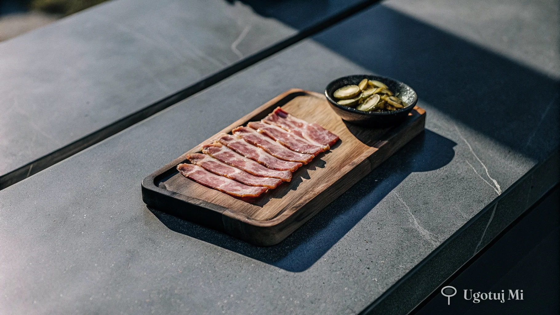Składniki na zrazy – plastry wołowiny, boczek i ogórki kiszone na desce | ugotujmi.pl