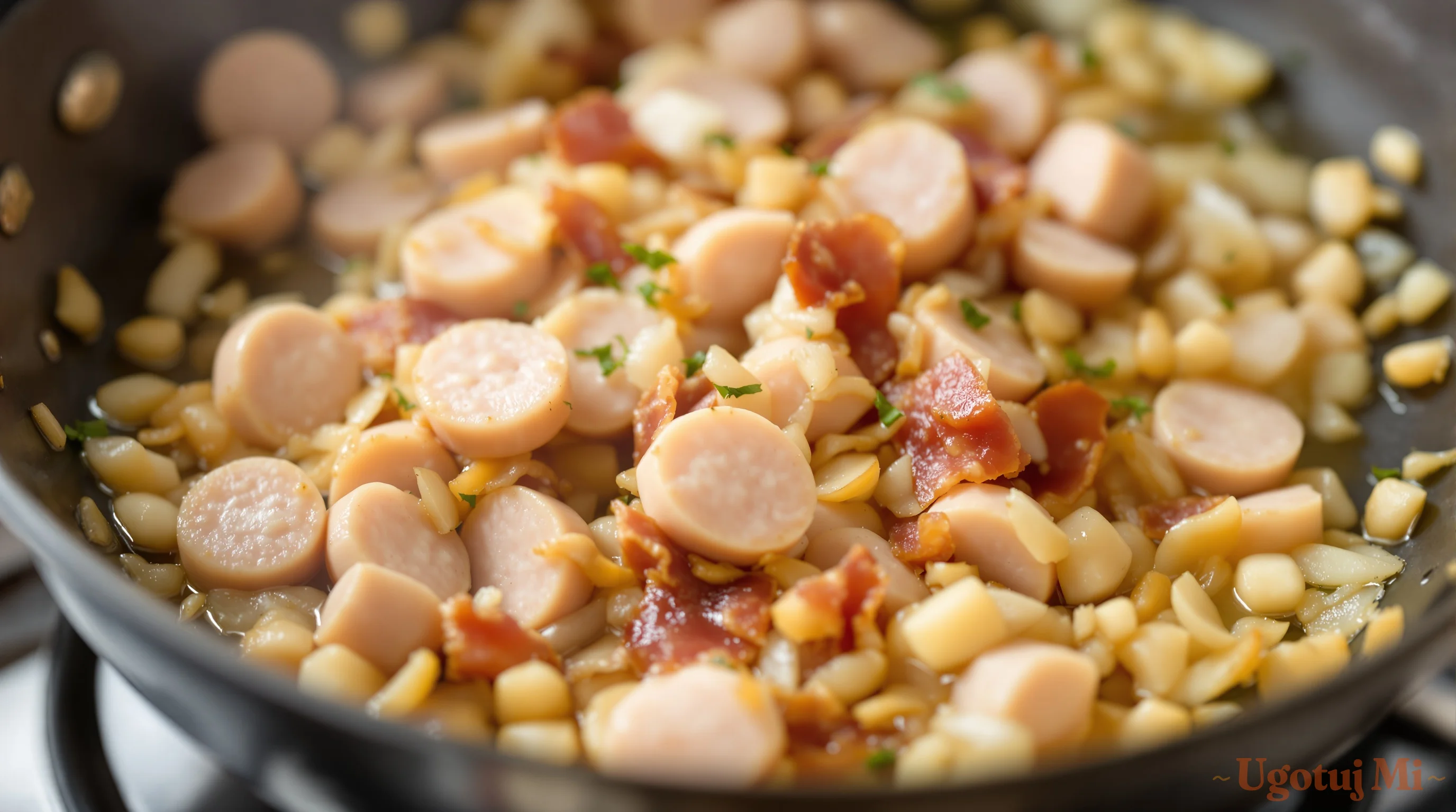 Podsmażana kiełbasa z boczkiem i cebulą na patelni | ugotujmi.pl